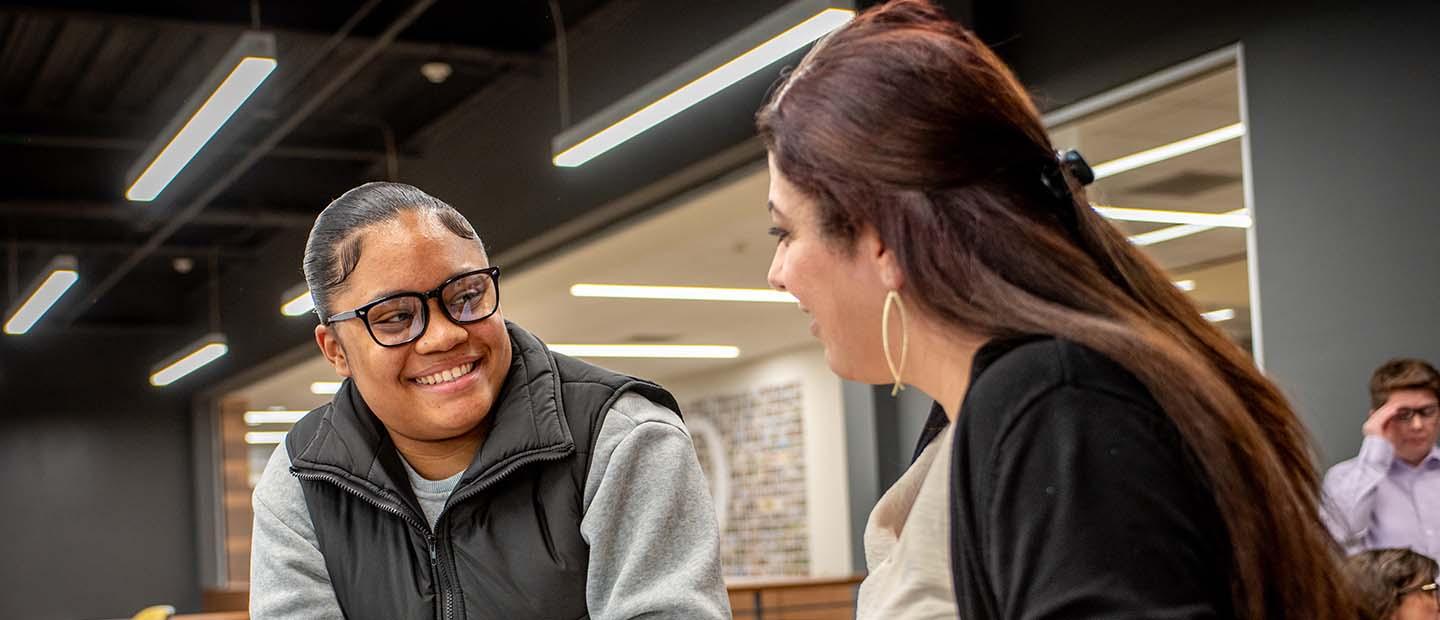 Two female students talking to eachother.